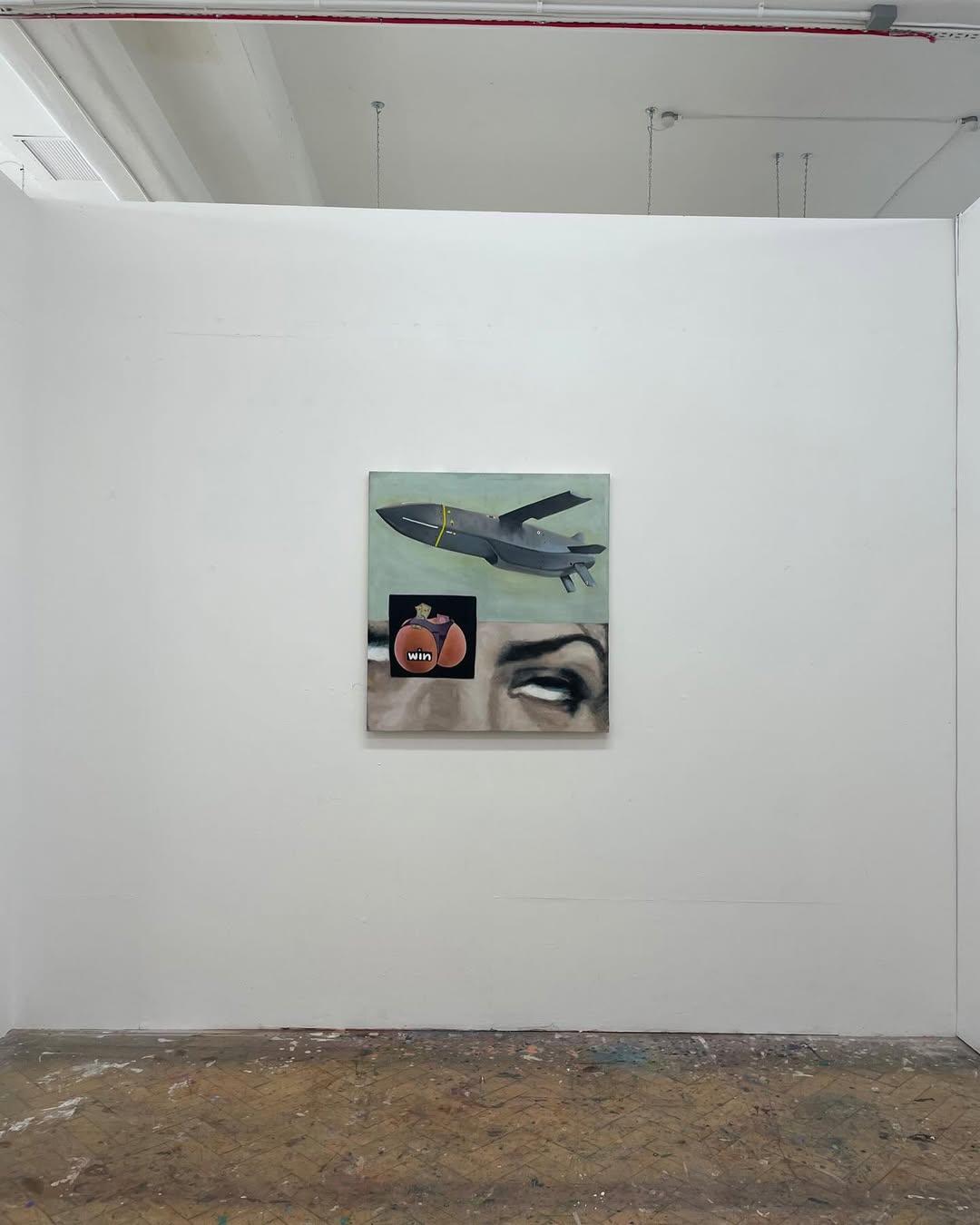 The painting hung at eye level on a white gallery wall, the clean surface above contrasting with the paint-splattered herringbone studio floor below