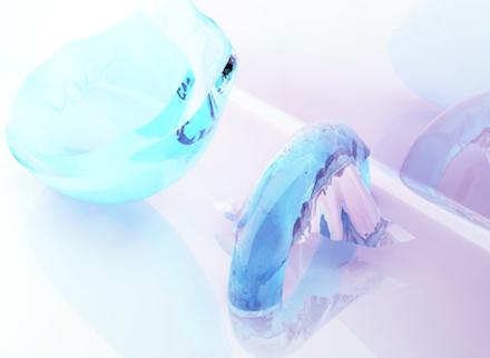 Translucent, ice-like objects resembling dental moulds in lavender and pale blue resin — the body made precious, memory given crystalline form
