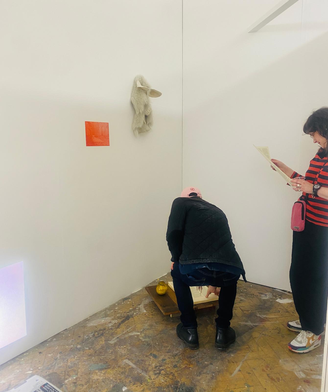 Visitors engaging with the installation, crouching to read the text